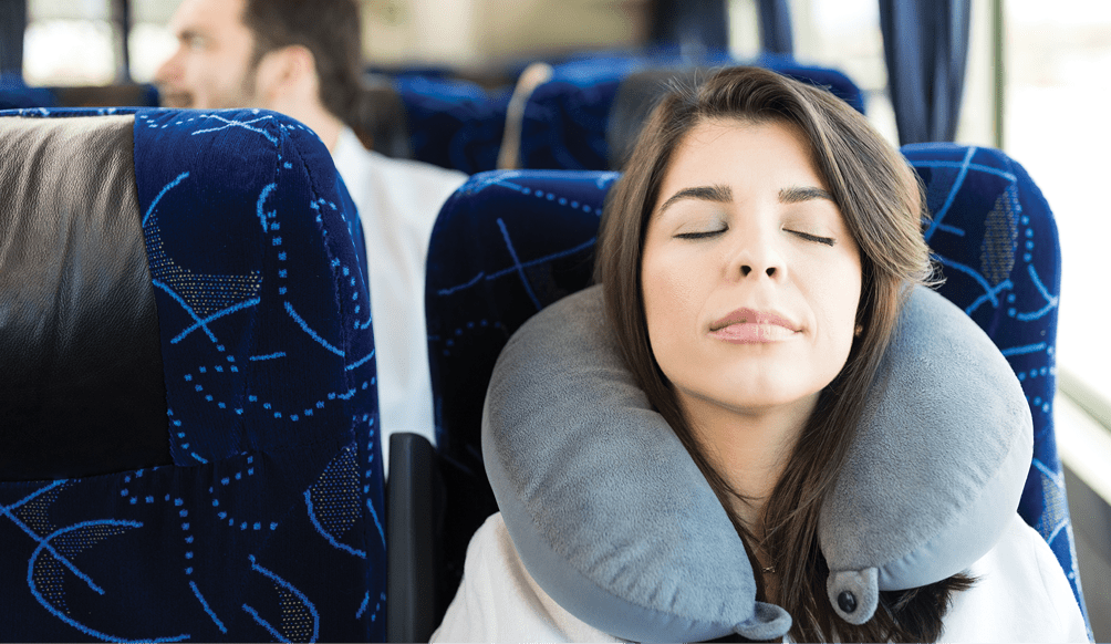 Mid adult passenger with neck pillow napping in travel bus 1151280225